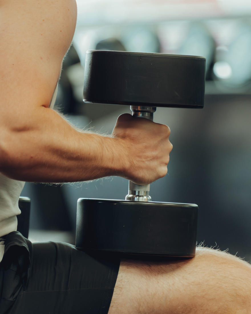 A member curling a dumbbell at The Forum